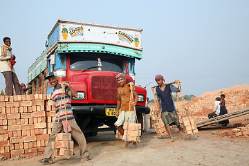 Image showing Brick field workers carrying complete finish brick