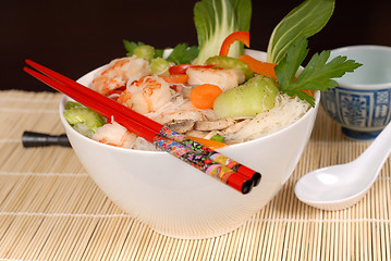 Image showing Udon noodles with vegetables and seafood with chopsticks