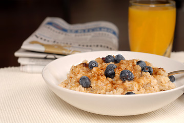 Image showing Bowl of oatmeal with brown sugar, blueberries, orange juice