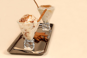 Image showing Two glasses of rice pudding with cinnamon on a black tray