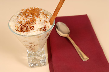 Image showing Glass of rice pudding with cinnamon with a maroon napkin