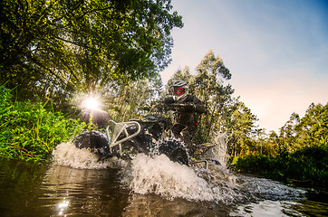 Image showing Quad rider through water stream