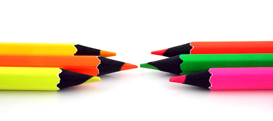 Image showing Neon pencils facing each other