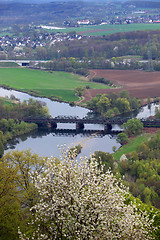 Image showing Bridge crossing a river at the green valley and farmland