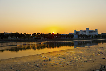 Image showing Sunset along river at factories
