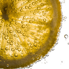 Image showing close-up of lemon slice in clear water with bubbles