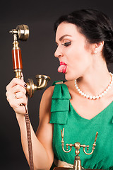 Image showing Attractive woman showing tongue into phone