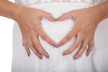 Image showing Woman holding her hands in a heart shape on her pregnant belly