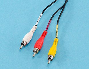 Image showing colorful tulip wire plugs on blue background 