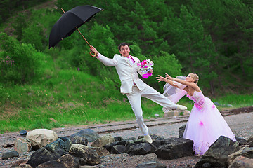 Image showing Groom with umbrella and bride - wedding joke