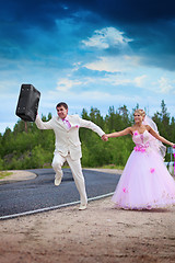 Image showing Groom with suitcase seeks for a honeymoon