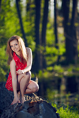 Image showing Girl siting on a log