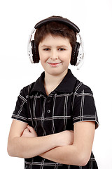 Image showing Portrait of a happy smiling young boy listening to music on headphones