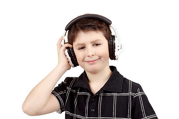 Image showing Portrait of a happy smiling young boy listening to music on headphones