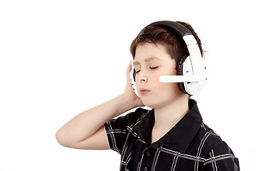 Image showing Portrait of a happy young boy listening to music on headphones