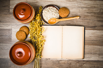 Image showing Oatmeal cookies and an old recipe book on the kitchen table 