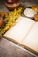 Image showing Oatmeal cookies and an old recipe book on the kitchen table 