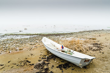 Image showing Old fishing boat at coast foggy in the morning