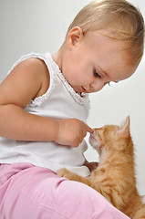 Image showing toddler child plays with a cat
