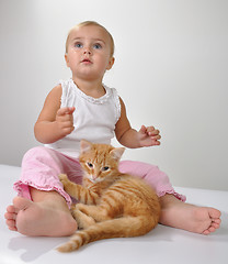 Image showing toddler child plays with a cat