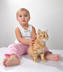 Image showing toddler child plays with a cat