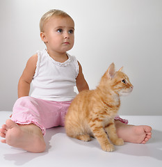 Image showing toddler child plays with a cat