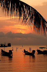 Image showing Sunset with palm and boats on tropical beach