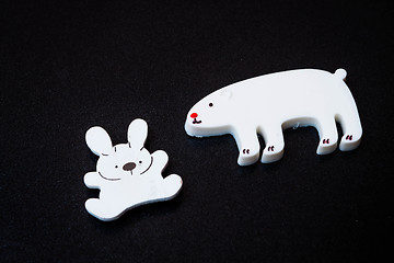 Image showing Close up white animal magnets on dark background