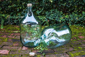 Image showing Recycle big glass wine on garden brick floor