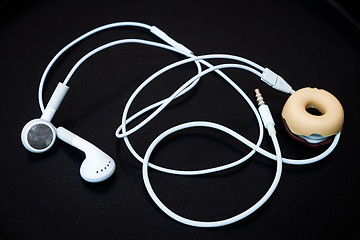Image showing White earphones with line store isolated on dark background