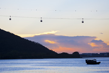 Image showing Sunset with cable cars background along coast in Hong Kong