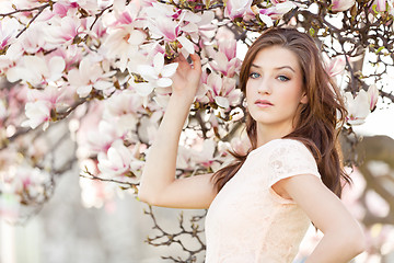 Image showing beautiful young woman and pink magnolia