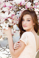 Image showing beautiful young woman and pink magnolia