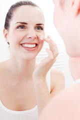 Image showing apllying cream on face skincare