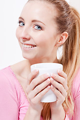 Image showing smiling young blonde woman drinking coffee