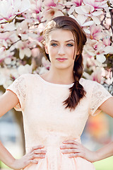 Image showing beautiful young woman and pink magnolia