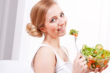 Image showing smiling woman eating fresh salad