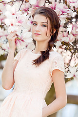 Image showing beautiful young woman and pink magnolia