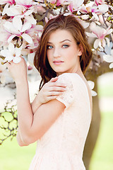 Image showing beautiful young woman and pink magnolia