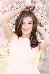 Image showing beautiful smiling woman and pink magnolia