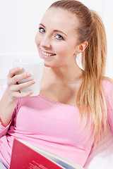 Image showing smiling young blonde woman drinking coffee
