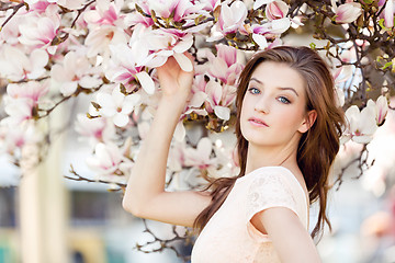 Image showing beautiful young woman and pink magnolia