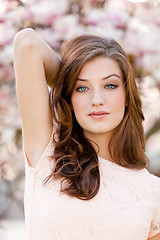 Image showing beautiful young woman and pink magnolia