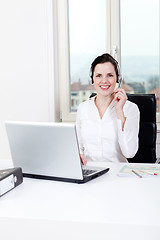 Image showing smiling young female callcenter agent with headset