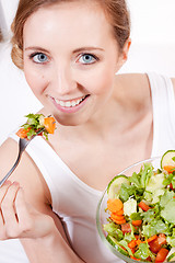 Image showing smiling woman eating fresh salad