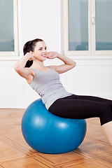 Image showing attractive young woman doing sit ups 