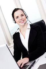 Image showing smiling young female callcenter agent with headset