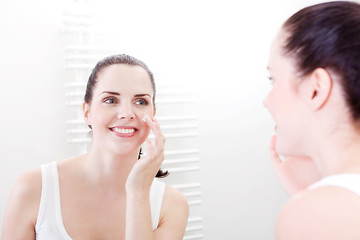 Image showing apllying cream on face skincare