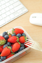 Image showing Healthy lunch box with strawberry and blueberry mix in office