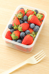 Image showing Healthy lunch box with strawberry and blueberry mix in office